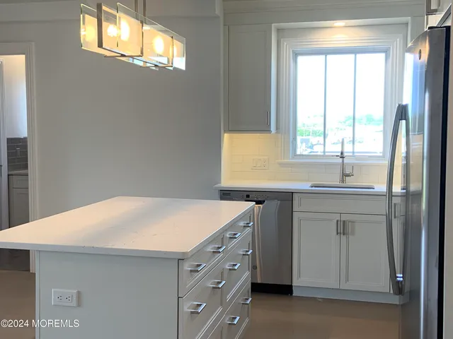 a kitchen with stainless steel appliances granite countertop a sink a stove and a refrigerator