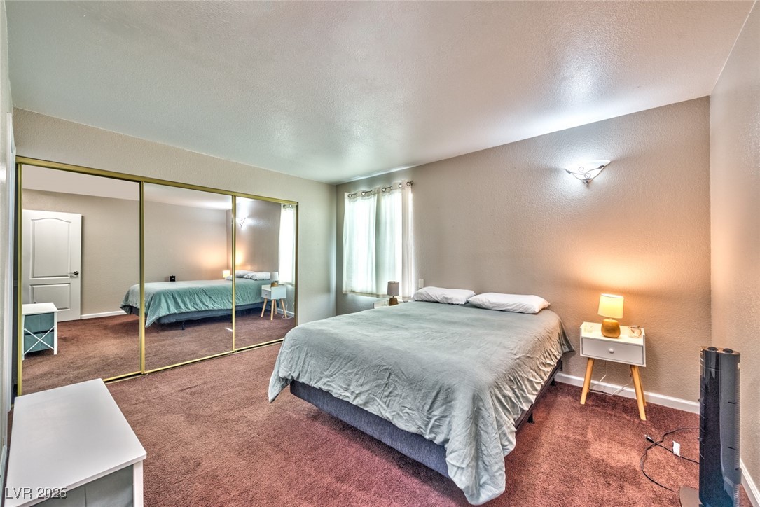 3145 East Flamingo Road, Unit 2068 Las Vegas, NV 89121 - Photo 10 of 15 Bedroom with a textured wall, carpet, a closet, and a textured ceiling
