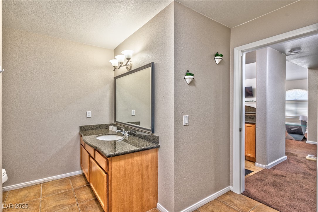 3145 East Flamingo Road, Unit 2068 Las Vegas, NV 89121 - Photo 14 of 15 Bathroom with a textured wall, vanity, a textured ceiling, and light tile patterned floors