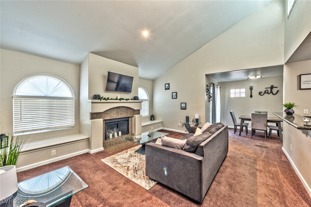 3145 East Flamingo Road, Unit 2068 Las Vegas, NV 89121 - Photo 8 of 15 Living area with a glass covered fireplace, carpet flooring, and high vaulted ceiling