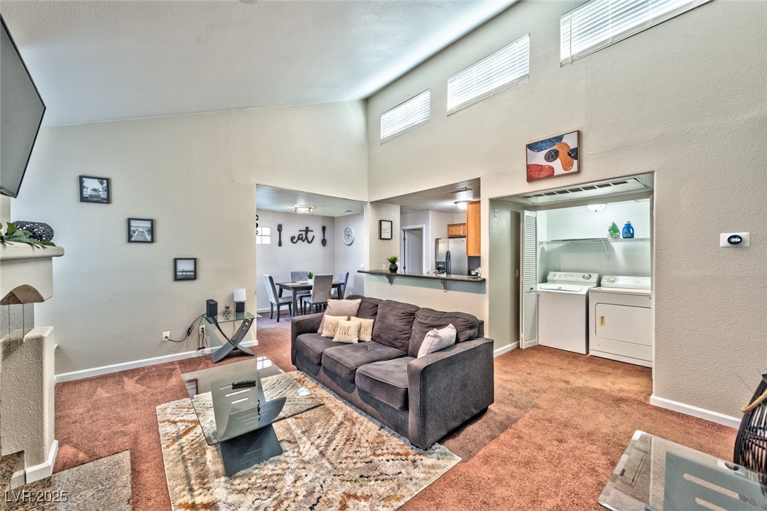 3145 East Flamingo Road, Unit 2068 Las Vegas, NV 89121 - Photo 9 of 15 Carpeted living area with a towering ceiling and washing machine and dryer