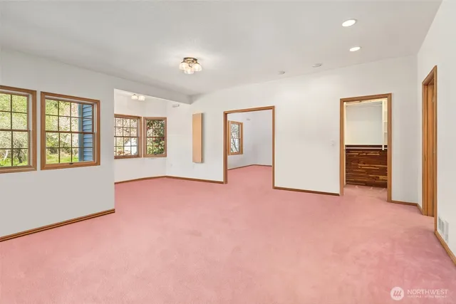 an empty room with windows and closet