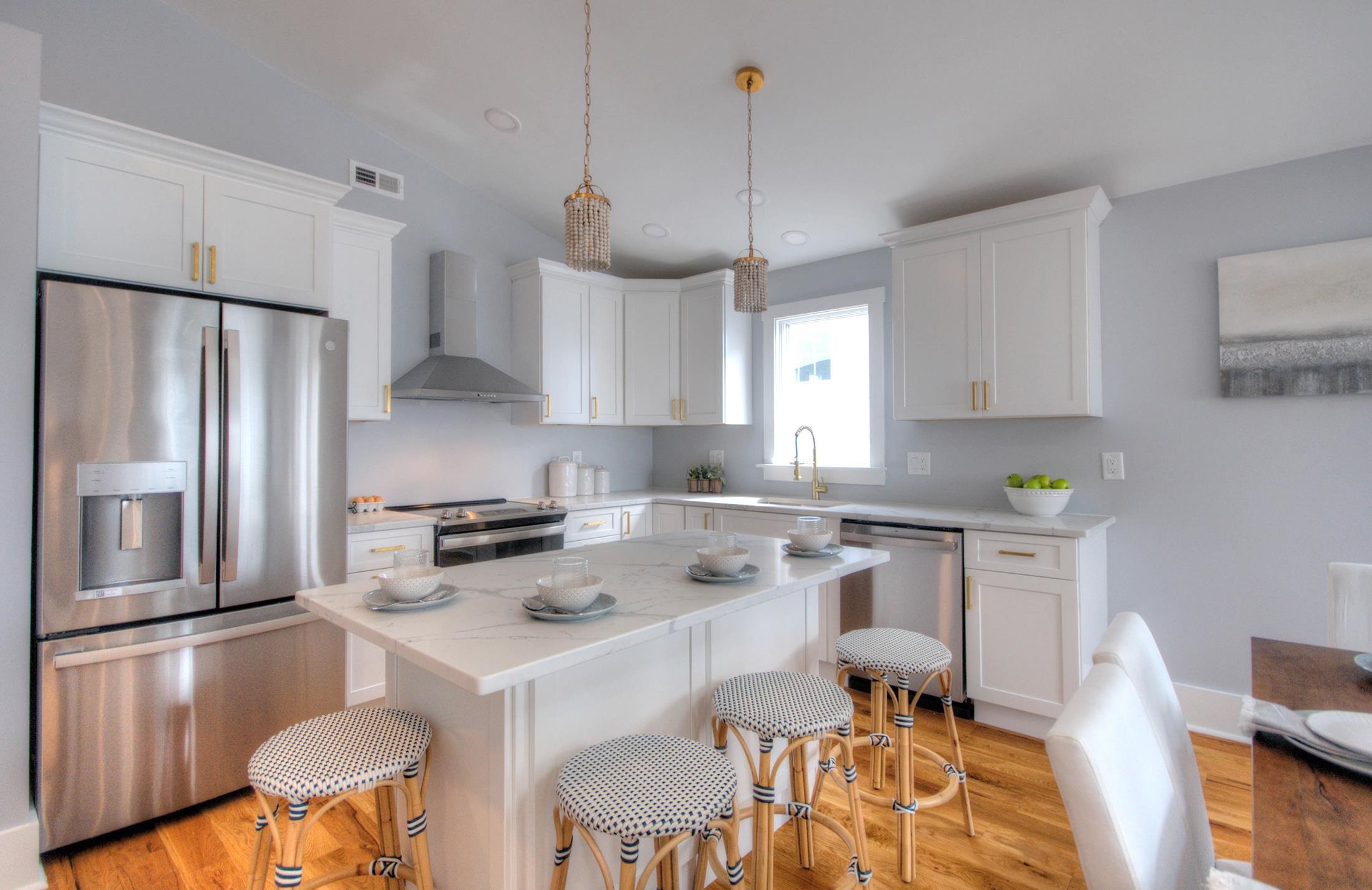 320 40th Street Avalon, NJ 08202 - Photo 14 of 39 a kitchen with stainless steel appliances granite countertop a stove a refrigerator a sink a dining table and chairs with wooden floor