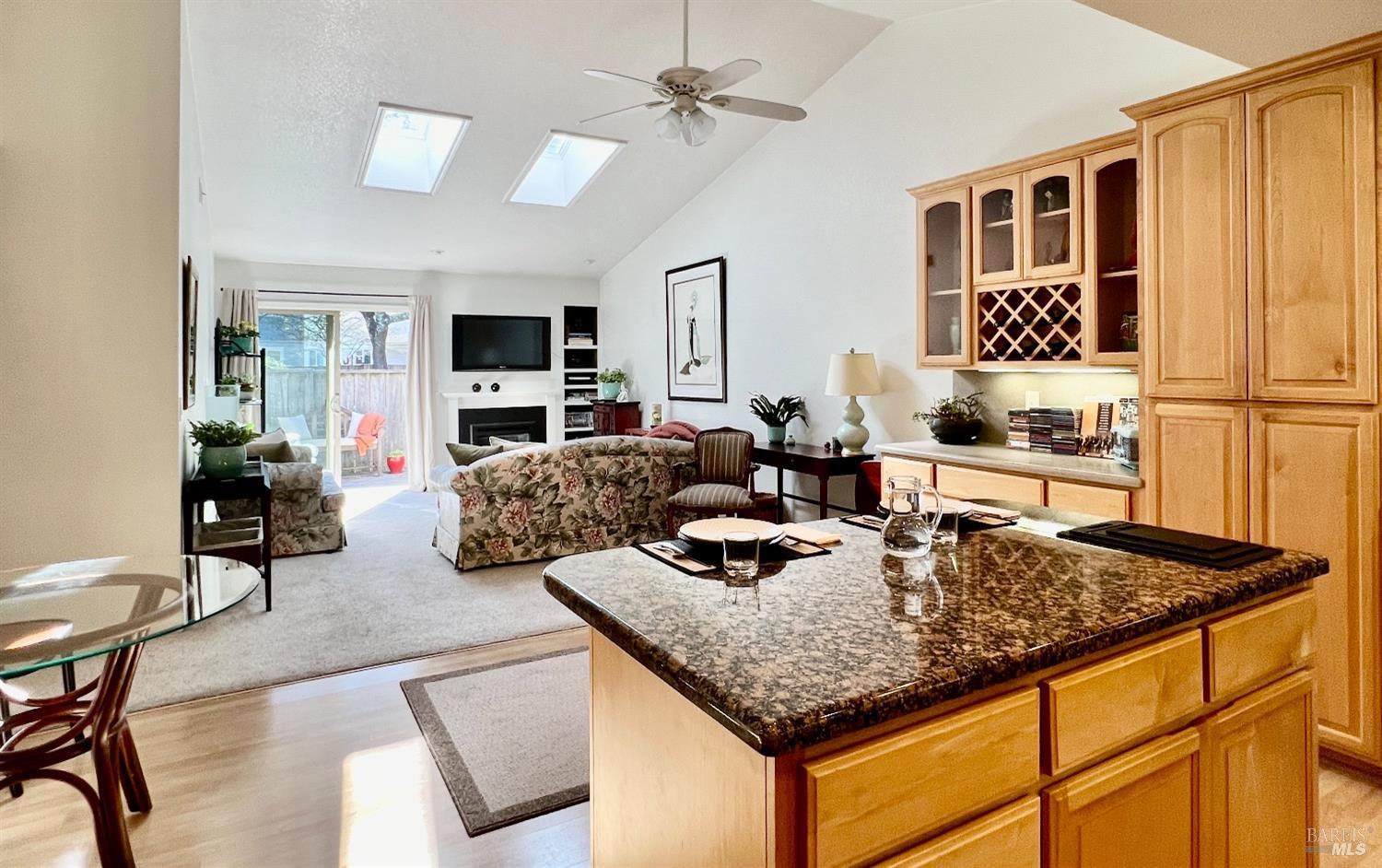 KITCHEN ¦ DINING ROOM ¦ LIVING ROOM ¦ LR WITH 2 SKYLIGHTS, GAS FIREPLACE INSERT AND DECK ACCESSING OUTDOORS WITH GAS BBQ HOOK-UP ¦ DECK OVERLOOKING HOA MAINTAINED GREEN SPACE ¦ INDOOR OUTDOOR LIVING