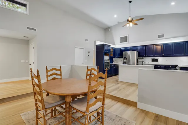 a living room with stainless steel appliances kitchen island a table and chairs