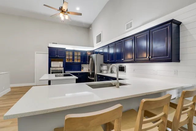 a kitchen with a sink a microwave and cabinets