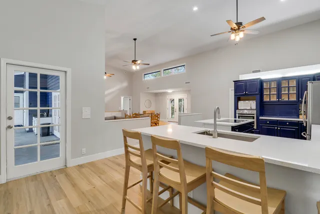 a kitchen with stainless steel appliances a dining table chairs and stove