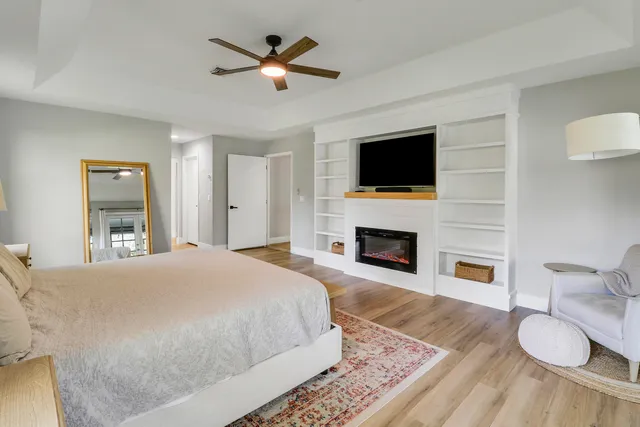 a spacious bedroom with a bed and a flat screen tv