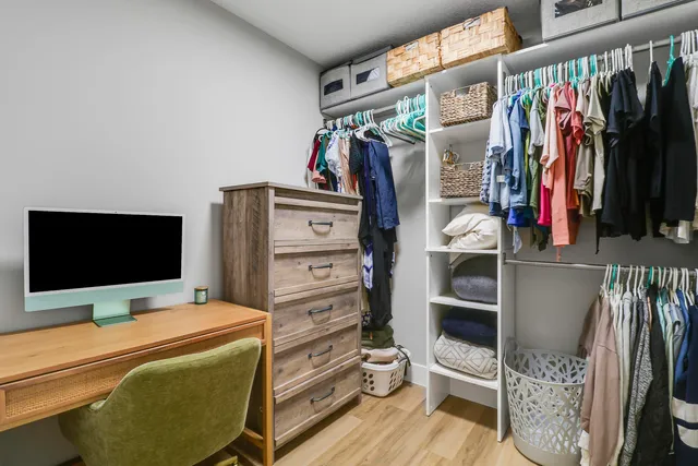 a view of walk in closet with clothes and shoes
