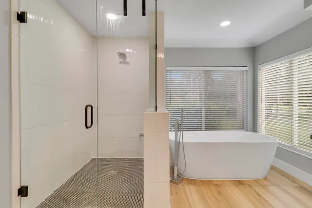 a view of bathroom with bathtub window and wooden floor