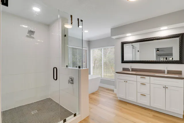 a bathroom with a tub a sink and mirror