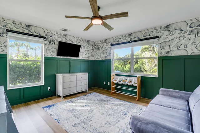 a work room with furniture a flat screen tv and a floor to ceiling window