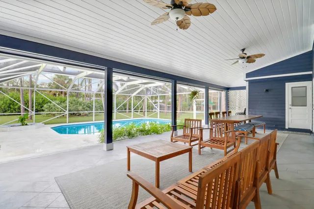 a dining room with furniture water view and a floor to ceiling window