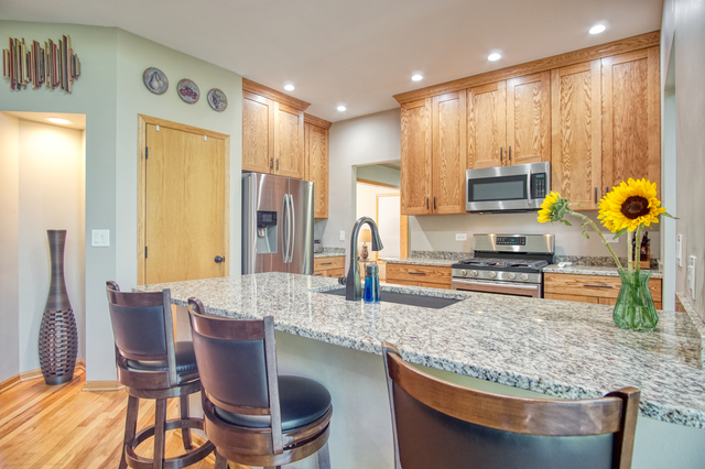 115 North Prospect Avenue Streamwood, IL 60107 - Photo 3 of 41 a kitchen with stainless steel appliances granite countertop a table chairs and a refrigerator