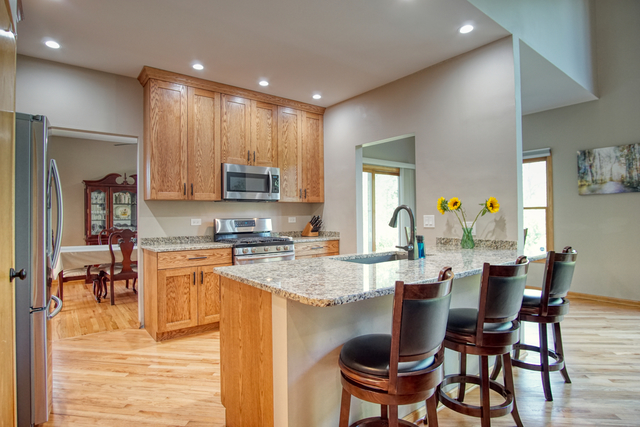 115 North Prospect Avenue Streamwood, IL 60107 - Photo 5 of 41 a kitchen with a dining table chairs and refrigerator