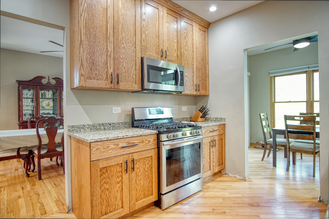 115 North Prospect Avenue Streamwood, IL 60107 - Photo 6 of 41 a kitchen with stainless steel appliances granite countertop a stove a sink and a microwave
