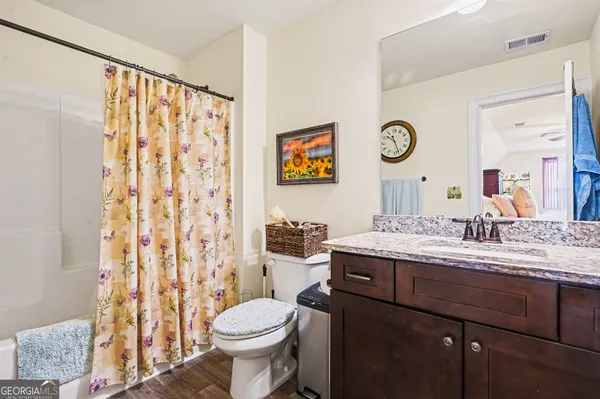 a bathroom with a granite countertop toilet sink and mirror