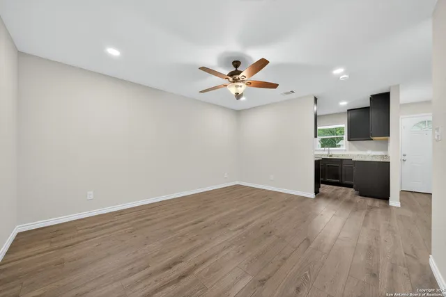 a view of a kitchen with wooden floor and a ceiling fan