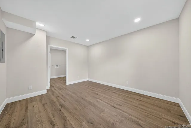 a view of an empty room with wooden floor