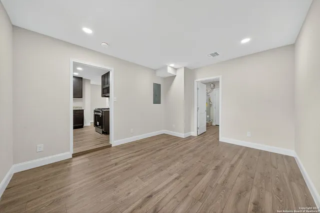 a view of an empty room with wooden floor
