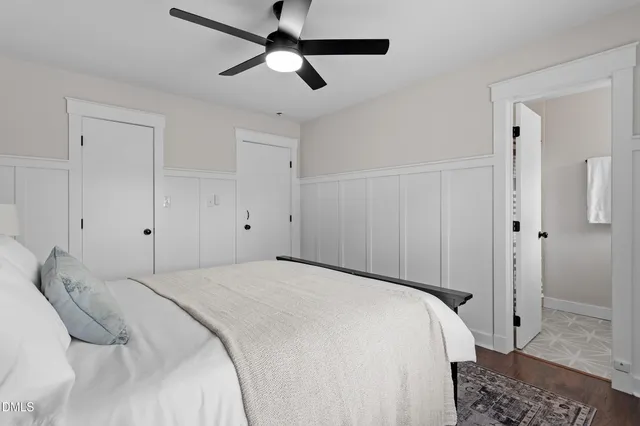a bedroom with a large bed and a chandelier fan