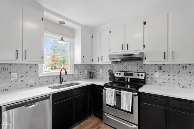 a kitchen with stainless steel appliances granite countertop a sink a stove and cabinets