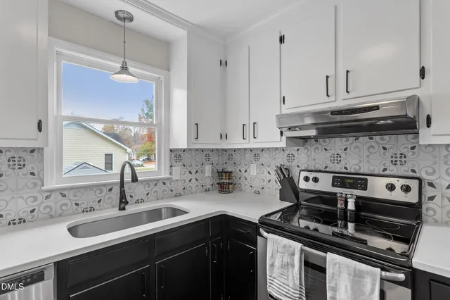 a kitchen with stainless steel appliances a stove a sink and cabinets