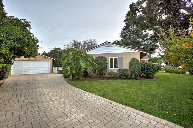 a front view of a house with a yard and trees