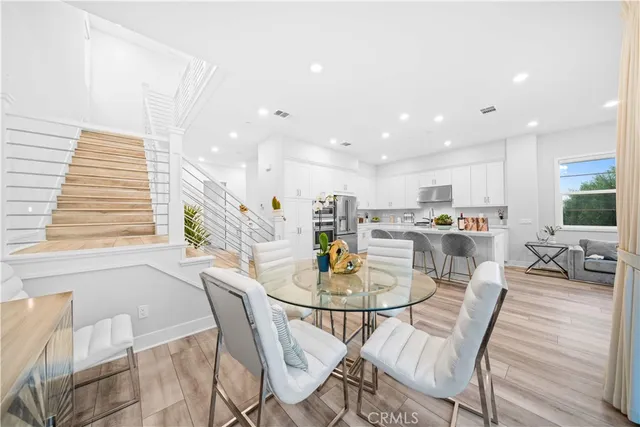 a view of a dining room and livingroom with furniture wooden floor and a rug
