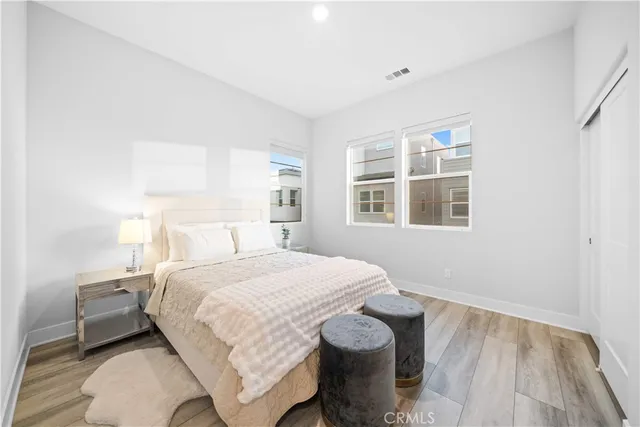 a bedroom with a bed and wooden floor
