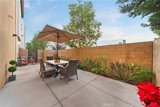 a view of a patio with a table and chairs under an umbrella