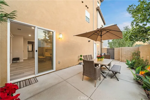 a view of a patio with table and chairs under an umbrella