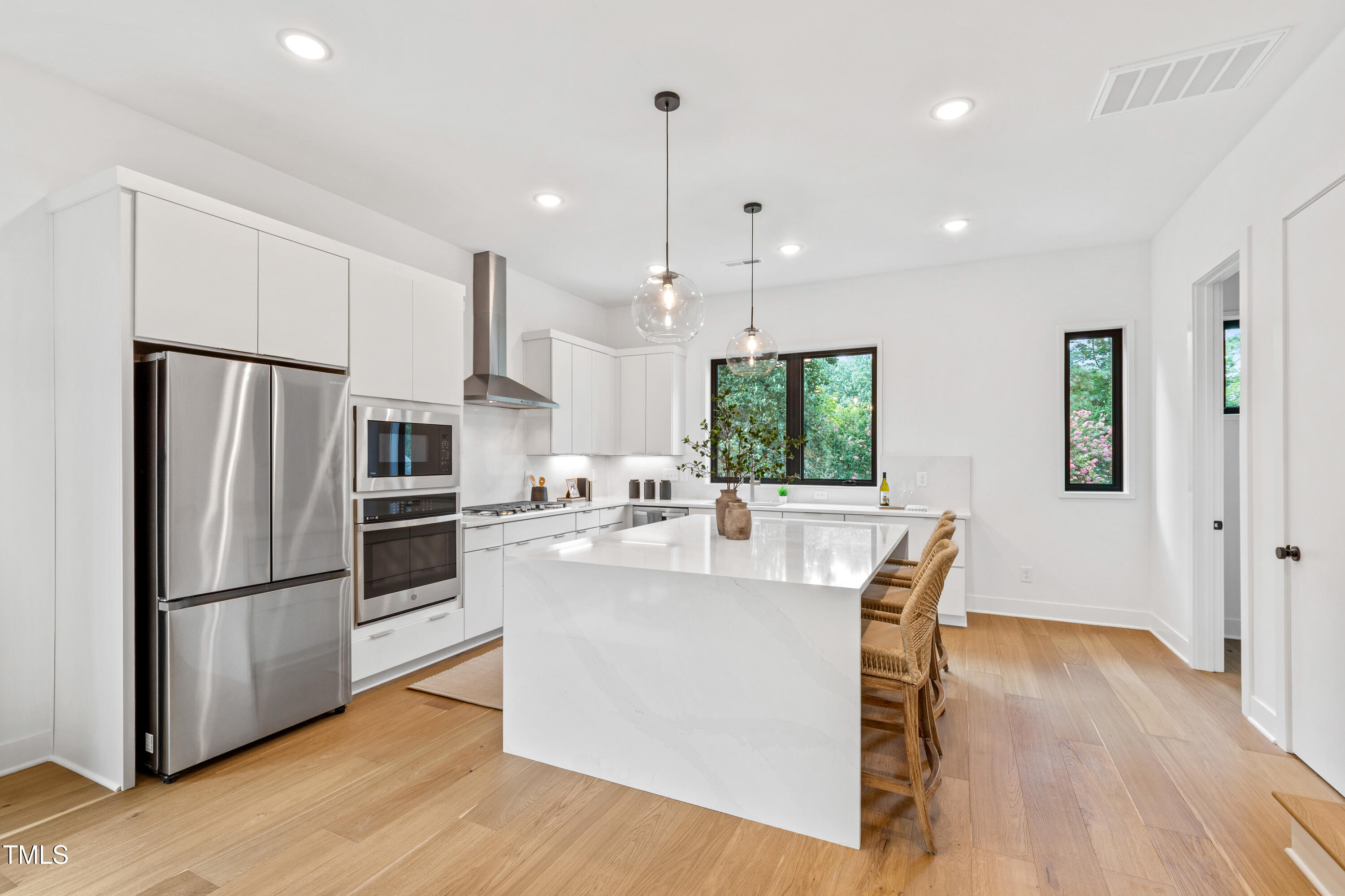 511 Edgecreek Court Raleigh, NC 27604 - Photo 12 of 58 a kitchen with stainless steel appliances a refrigerator a stove a sink dishwasher and a dining table with wooden floor