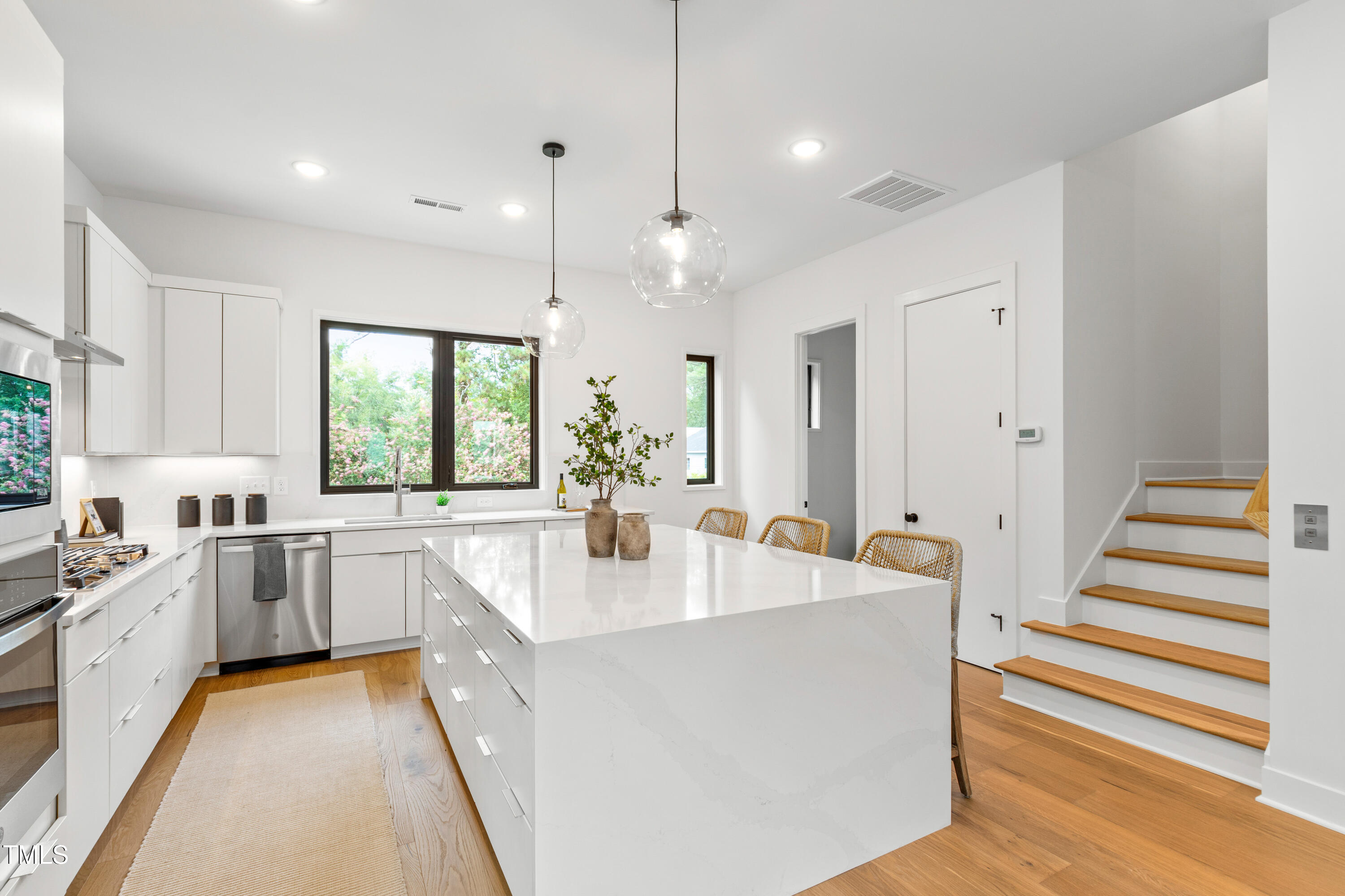 511 Edgecreek Court Raleigh, NC 27604 - Photo 13 of 58 a large white kitchen with a stove a sink a chimney wooden floor and cabinets