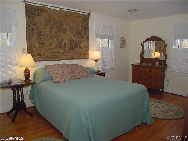 3017 Williamswood Road Richmond, VA 23235 - Photo 8 of 12 a bedroom with a bed and wooden floor