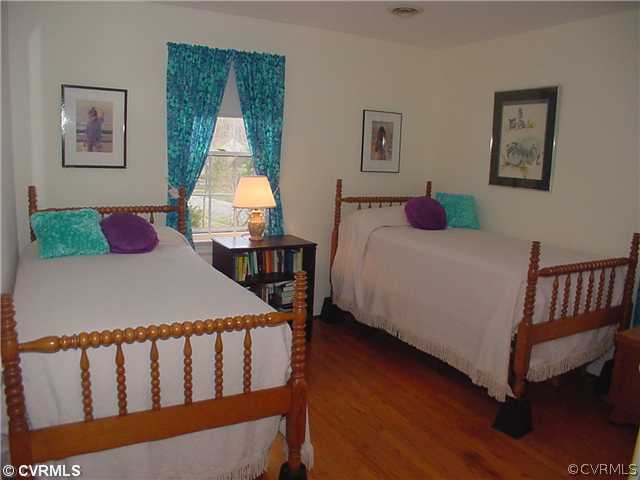3017 Williamswood Road Richmond, VA 23235 - Photo 10 of 12 a bedroom with a bed and wooden floor