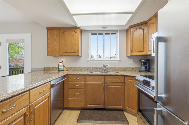 45 West 100 South Mendon, UT 84325 - Photo 16 of 64 Kitchen with stainless steel appliances, wood finish cabinets, light stone countertops, and light wood finished floors