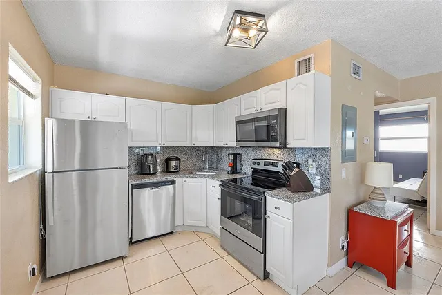 a kitchen with stainless steel appliances a refrigerator stove microwave and sink