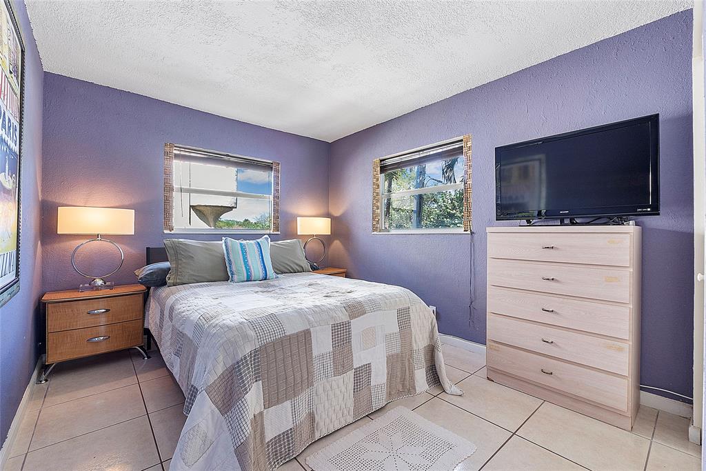 2741 Northeast 8th Avenue, Unit 20 Wilton Manors, FL 33334 - Photo 5 of 25 a bedroom with a bed and a flat screen tv