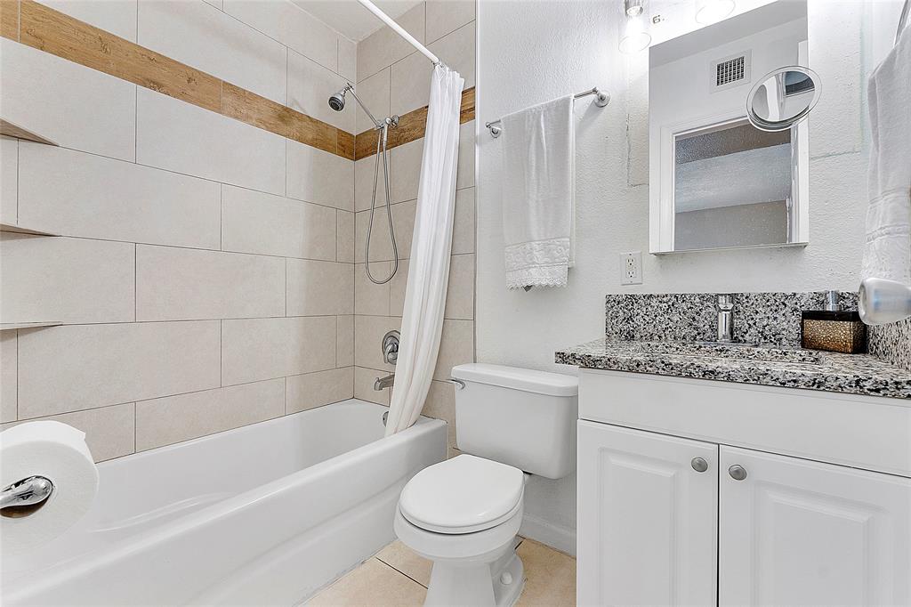 2741 Northeast 8th Avenue, Unit 20 Wilton Manors, FL 33334 - Photo 7 of 25 a bathroom with a granite countertop toilet a sink and bathtub