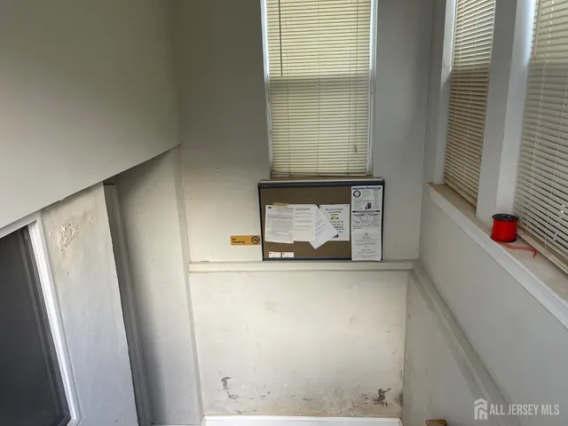 a view of a storage and utility room with fridge and window