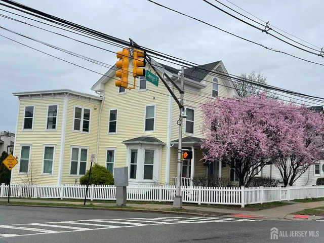 a view of a white house with a street