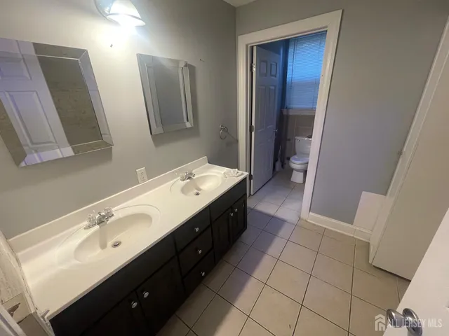 a spacious bathroom with a double vanity sink and mirror