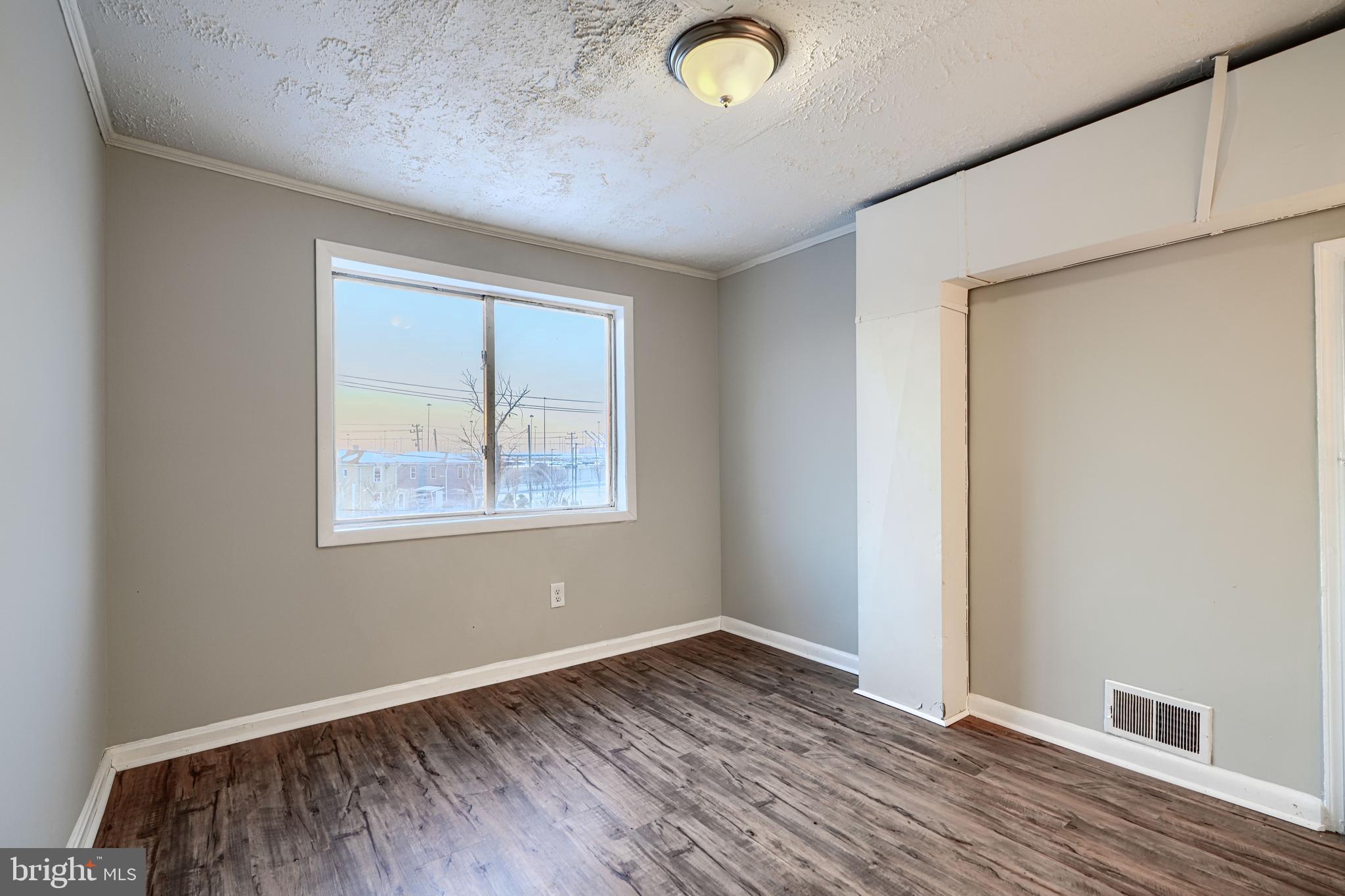 402 Chestnut Court Dundalk, MD 21222 - Photo 20 of 36 an empty room with wooden floor and windows