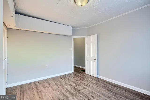an empty room with wooden floor and window