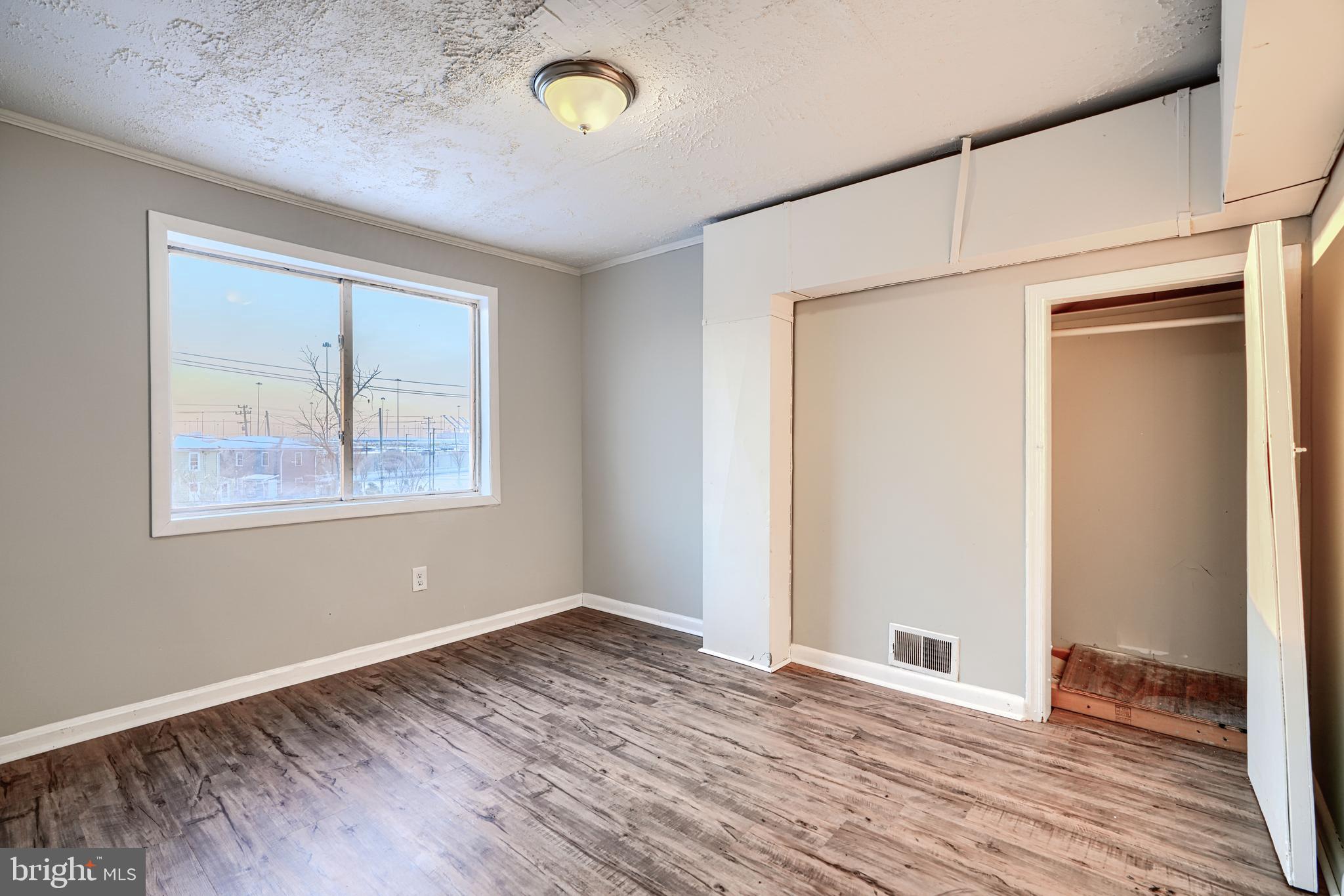 402 Chestnut Court Dundalk, MD 21222 - Photo 22 of 36 an empty room with wooden floor and window