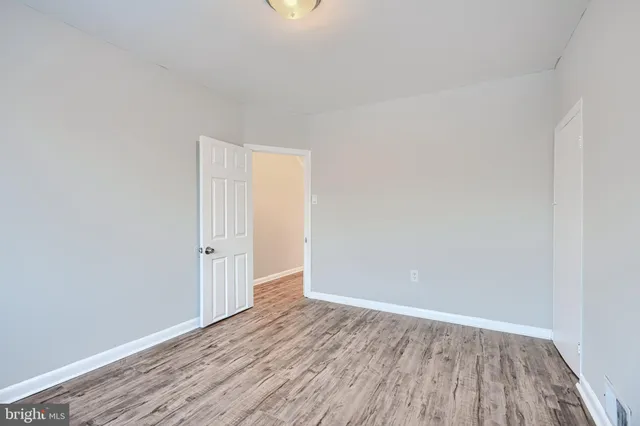 an empty room with a door and wooden floor