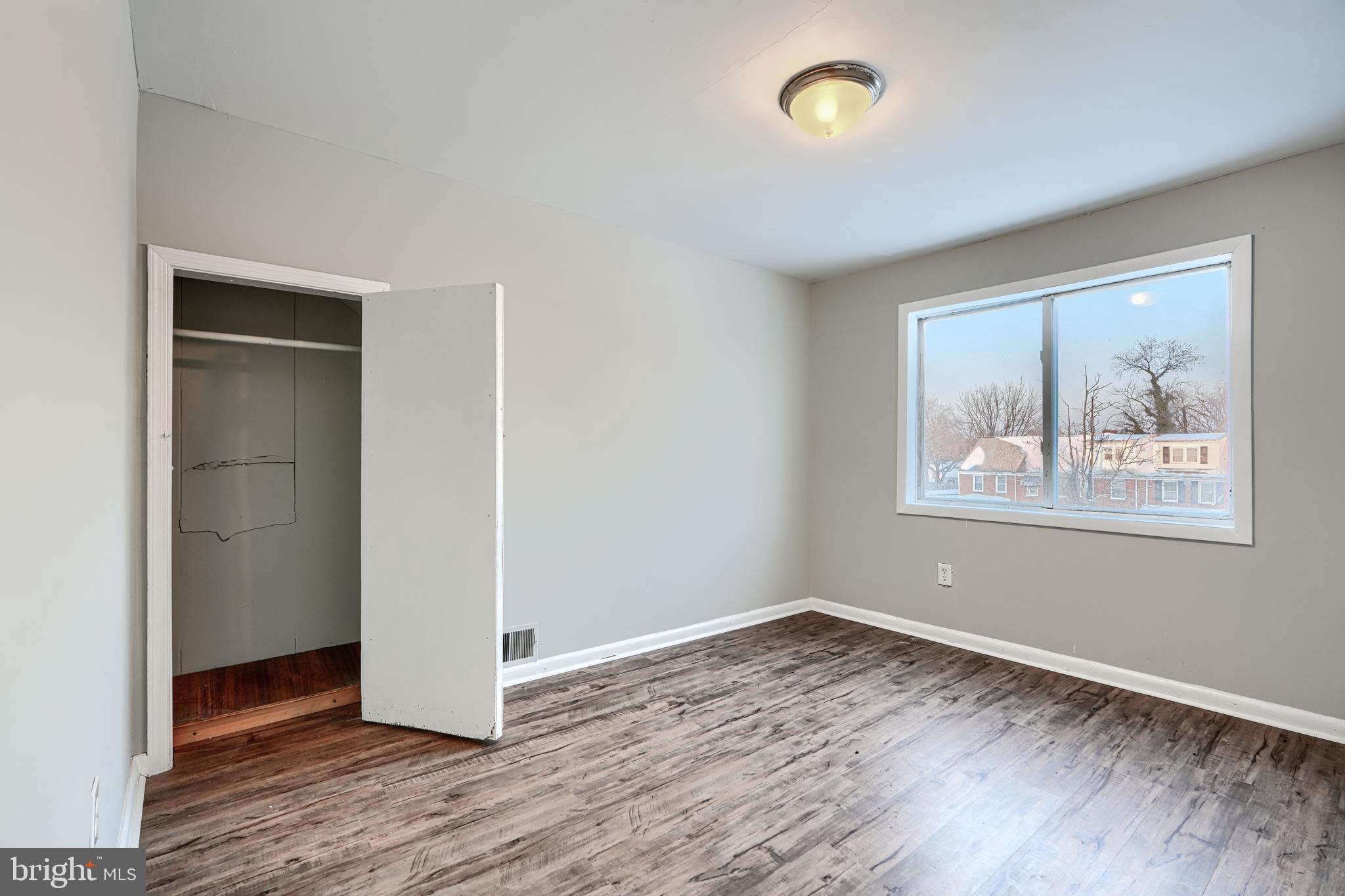 402 Chestnut Court Dundalk, MD 21222 - Photo 25 of 36 an empty room with a door and wooden floor