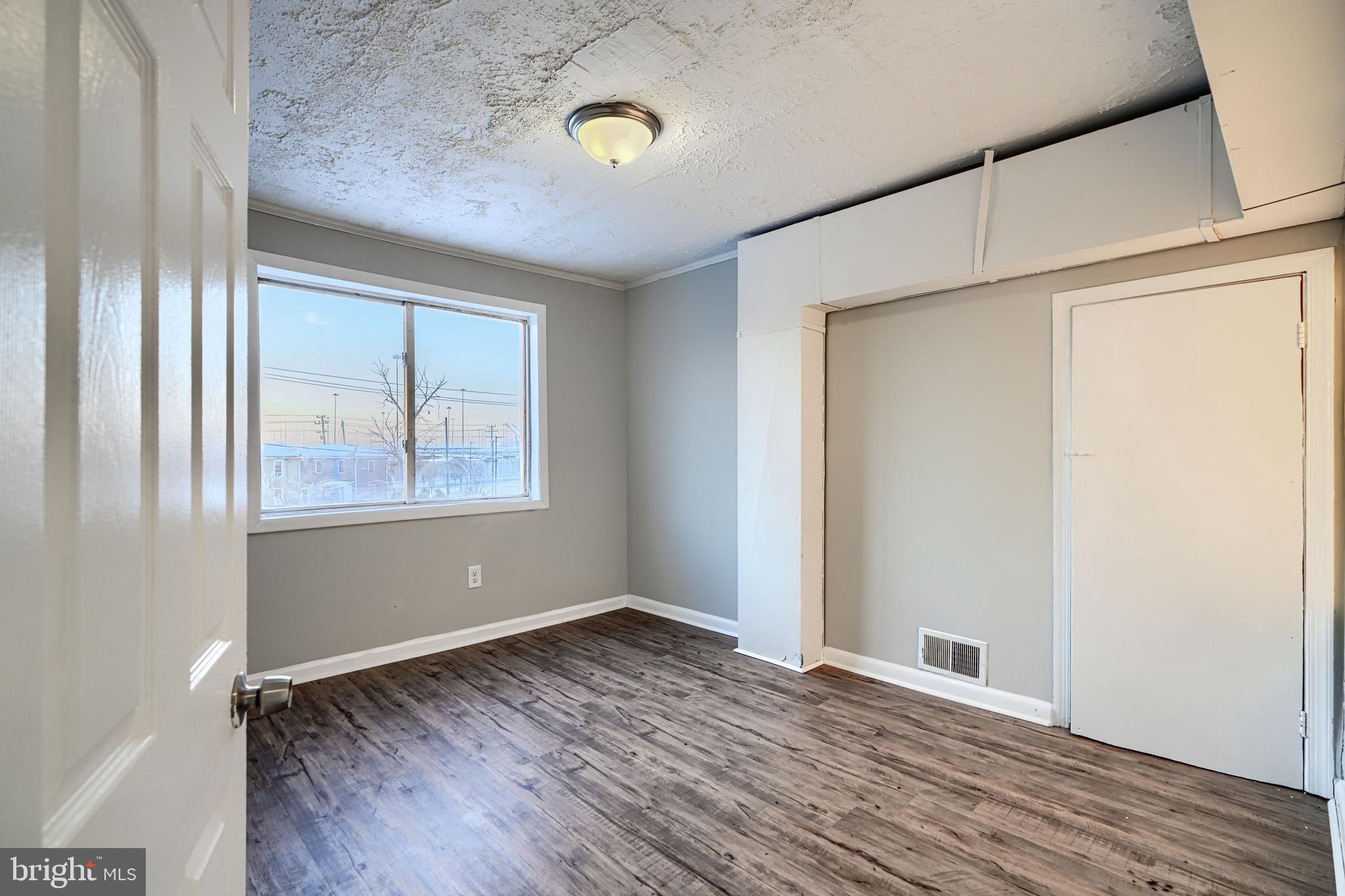 402 Chestnut Court Dundalk, MD 21222 - Photo 26 of 36 an empty room with wooden floor and windows