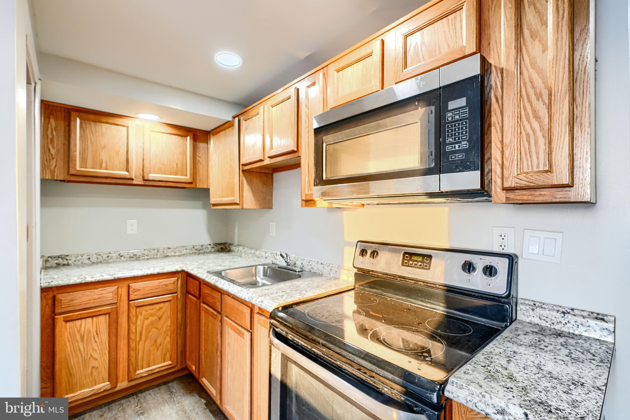 402 Chestnut Court Dundalk, MD 21222 - Photo 27 of 36 a kitchen with stainless steel appliances granite countertop a stove and a microwave